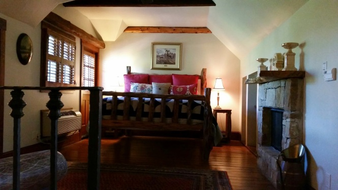 Door to balcony on left, King log bed and fireplace